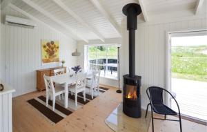 a kitchen and dining room with a wood stove at Three-Bedroom Holiday Home In Grenaa in Grenå