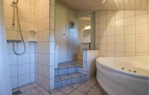 un bagno bianco con vasca e doccia di Holiday Home Sønder Vasevej Blåvand Iv a Blåvand