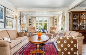 a living room with a couch and a table at Amazing Home In Skjoldastraumen in Skjoldastraumen