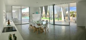 a dining room with a table and white chairs at TURQUESA 1 e TURQUESA 2 Fuerteventura in La Oliva