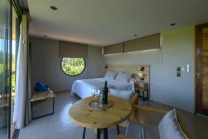 a bedroom with a bed and a table with a wine bottle on it at Posada Mawida in Maipú