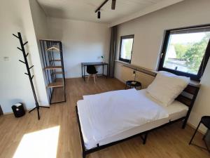 魏登Charmantes 2 BR Apartment mit Parkplatz的一间卧室，有一张白色的床和一扇窗户