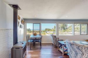 a living room with a stove and a table with chairs at Sea Esta in Fort Bragg +43 photos