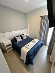 a bedroom with a bed with blue sheets and a window at DOMUM 144 in San Juan