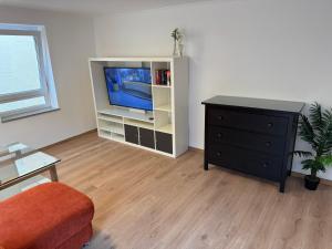 a living room with a television and a dresser at Wohnen - An der alten Stadtmauer in Rottenburg