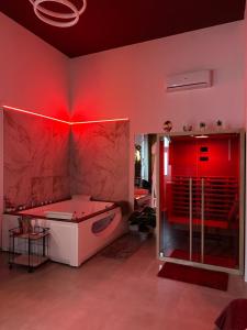bagno con illuminazione rossa e vasca di Atanasia Suite ad Acireale