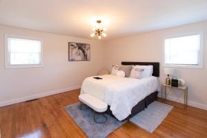 a bedroom with a bed with a white comforter at The Charles-South Shore in Randolph