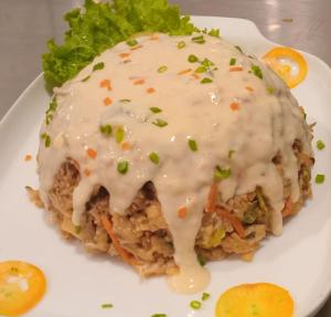 a white plate with a sandwich with sauce and green onions at Hotel Rosenro in Piliyandala
