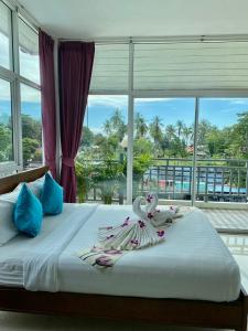 a bedroom with a bed with a large window at Lanta Just Come Hotel in Ko Lanta