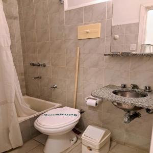a bathroom with a toilet and a sink and a tub at Bologna Hotel Mar del Plata in Mar del Plata +34 photos