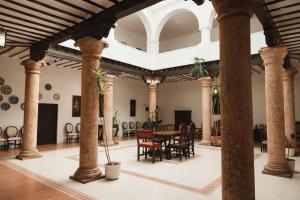 a large room with columns and a table and chairs at Casa de los Acacio in San Clemente