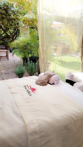 a large white bed with a stuffed animal on it at Posada Amatenco & Spa Tepoztlán in Tepoztlán +39 photos