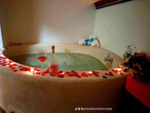 a bath tub with a bottle of wine and a glass at Posada Amatenco & Spa Tepoztlán in Tepoztlán +39 photos