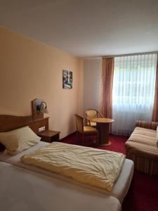 a hotel room with two beds and a table and a chair at Zur Turmstube in Dossenheim