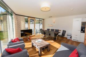 a living room with couches and a table and a dining room at Residenz Wildkogelbahnen Top 18 in Neukirchen am Großvenediger