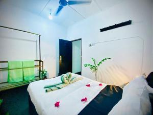 a bedroom with a white bed with flowers on it at The White Villa in Hikkaduwa