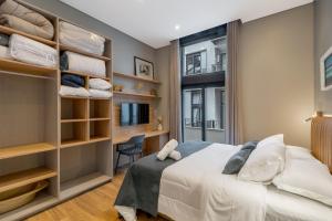 een slaapkamer met een bed, een bureau en een raam bij Luxo e Estilo no centro by Achei Gramado in Gramado