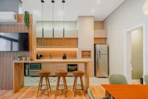 een keuken met een aanrecht en krukken. bij Luxo e Estilo no centro by Achei Gramado in Gramado