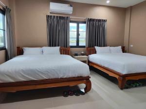 a bedroom with two beds and a window at Modern House CNX in Chiang Mai