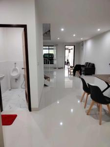 Una sala de estar blanca con una mesa y sillas. en Modern House CNX, en Chiang Mai