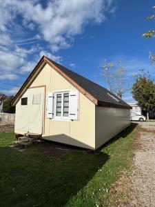 a small white shed with a roof on a yard at Chalet Mo in Bagnères-de-Bigorre