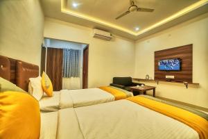 a hotel room with two beds and a tv at Hotel Visa Inn 4kms from Airport l Free Airport pickup & drop 24x7 in Bengaluru