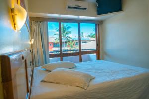 Cama ou camas em um quarto em Porto das Naus Praia Hotel