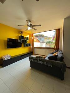 a living room with a couch and a ceiling fan at Nerone's House Villa with garden near the sea, ideal for family in Anzio