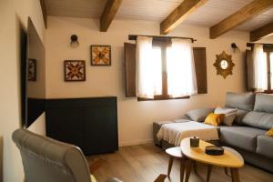 Una sala de estar con un sofá y un televisor. en La Casita de los Pájaros, en San Martín de Valdeiglesias