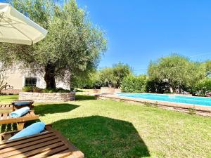 a backyard with a swimming pool and an umbrella at Kostas Beach Estate with private pool by DadoVillas in Astrakeri