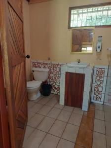 a bathroom with a toilet and a sink at KintsugiKanjiatCocles in Cocles