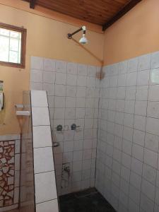 a bathroom with a shower with white tiles at KintsugiKanjiatCocles in Cocles +16 photos