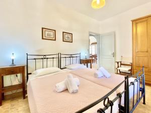 a bedroom with a large bed with two towels at Kostas Beach Estate with private pool by DadoVillas in Astrakeri +33 photos
