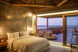 ein Schlafzimmer mit einem Bett und einem Balkon mit Meerblick in der Unterkunft Yemanjá Hotel by Preabeach Experience in Prea