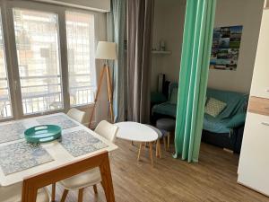 a small kitchen and living room with a table and chairs at T1Bis centre d'Arcachon avec balcon in Arcachon