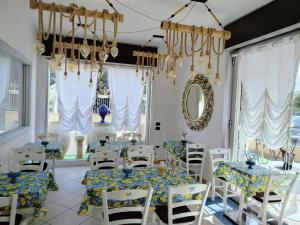 a dining room with tables and chairs and a chandelier at Costa Costa Rooms in Sant'Egidio del Monte Albino