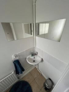 a bathroom with a sink and two mirrors at 4 Bed House - Sleeps 8 - Parking - Garden - Wifi in Buckingham +3 photos