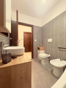 a bathroom with a sink and a toilet and a tub and a sink at GC Hejme Locazione Turistica in Lunghezza