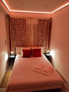 a bedroom with a bed with two red pillows at Vista Panorâmica Amadora RC in Amadora