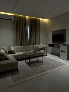 een woonkamer met een bank en een salontafel bij شقق طلال الفندقية- Talal hotel apartments in Al Ula