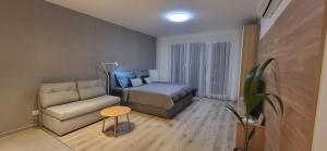a small room with a bed and a couch at River Living Apartman in Budapest