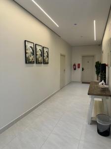 Una gran habitación blanca con cuadros en la pared. en شقق طلال الفندقية, en Al Ula
