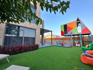 a yard with green grass and a playground at DrVillaSuits Casa Riva in Belek