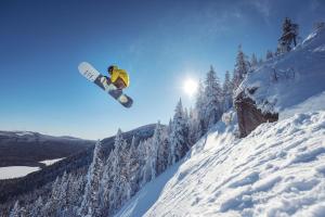 a man flying through the air while riding a snowboard at La Maison Big Bill in Murdochville