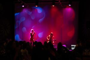 two musicians on a stage with purple lights at La Maison Big Bill in Murdochville