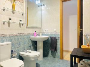 Un baño con un inodoro blanco y un lavabo. en La Casa del Cuco, en Almodóvar del Río 29 fotos más
