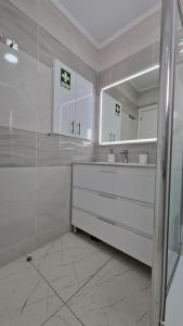 een witte badkamer met een wastafel en een spiegel bij Casa Belice in Vila Real de Santo António +12 foto's