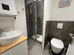 une salle de bain avec une douche, un lavabo et des toilettes dans l'établissement Studio Grey Stone - Parking gratuit - Clim, à La Grande Motte
