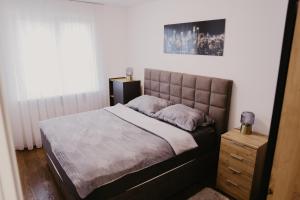 une chambre avec un lit, une commode et une fenêtre dans l'établissement Regnare Residence, à Zagreb
