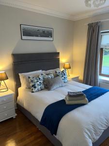 una camera da letto con un grande letto con cuscini blu e bianchi di Carraig House Cozy countryside apartment a Cavan
